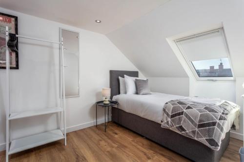 a white bedroom with a bed and a window at Briarhill - Donnini Apartments in Prestwick