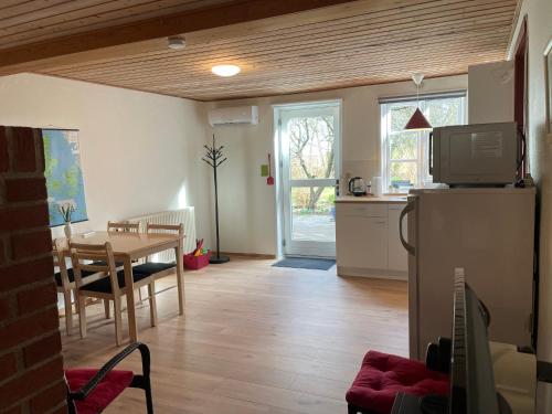 a kitchen and dining room with a table and a refrigerator at Kragh B&B in Løsning