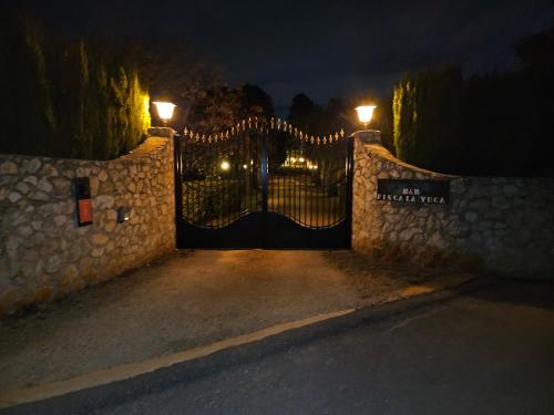 a gate to a house at night with lights at B&B Finca la Yuca "Un paraíso en Ontinyent" in Ontinyent