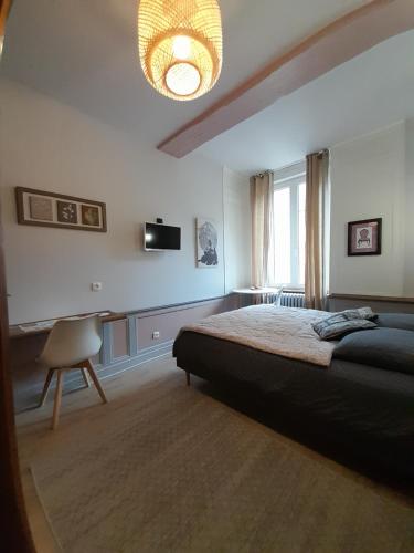 Un dormitorio con una cama grande y una lámpara de araña. en Chambre d'hôtes indépendante, en Fougères