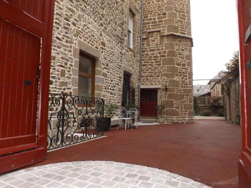 una entrada a un edificio de ladrillo con una puerta roja en Chambre d'hôtes indépendante, en Fougères