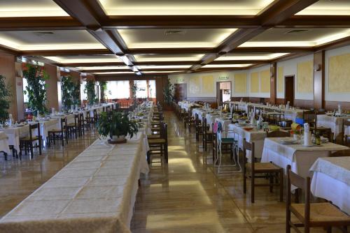 uma fila de mesas e cadeiras num salão de banquetes em Hotel Miramonti em Sestola