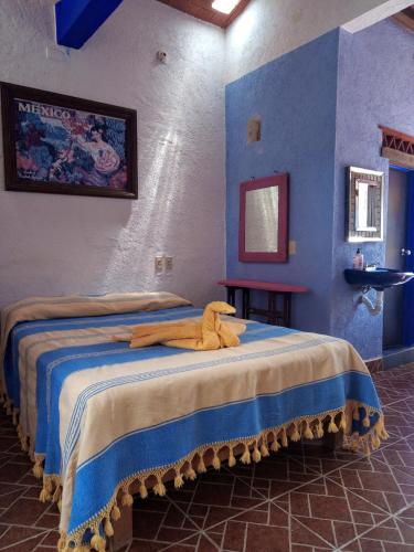 - une chambre avec 2 lits aux murs bleus dans l'établissement La lagartija, à San Pablo Etla