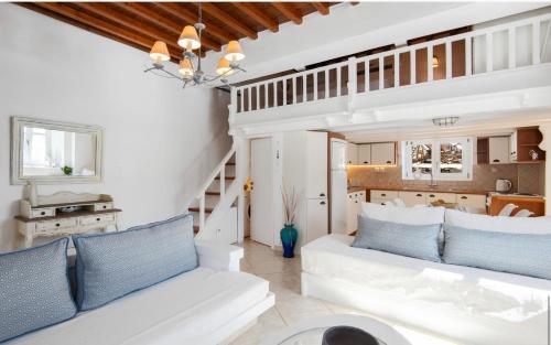 uma sala de estar com um sofá branco e almofadas azuis em Apanemo em Faros