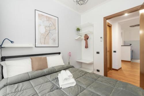 1 dormitorio con 1 cama grande y pasillo en White Rooms Colosseo, en Roma