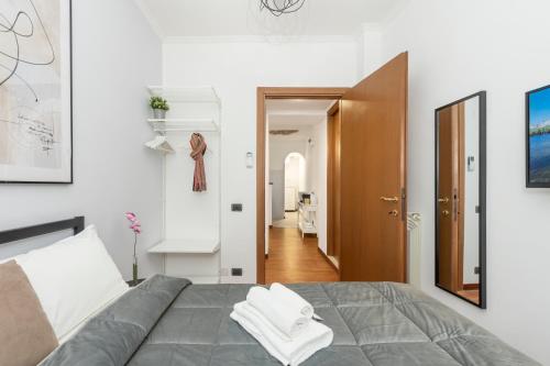 Un dormitorio con una cama con toallas blancas. en White Rooms Colosseo, en Roma