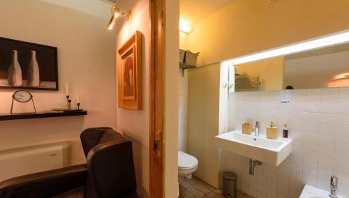ein Badezimmer mit einem Waschbecken, einem WC und einem Spiegel in der Unterkunft Appartamento studio e design in centro storico Sulmona in Sulmona