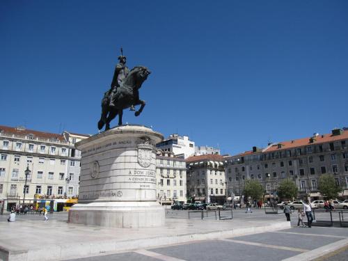 a statue of a man on a horse in a city at Hotel Lis Baixa in Lisbon