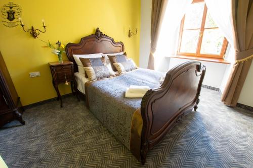 a bedroom with a large bed in a yellow room at Pałac Lubiechowa-Jelenia Góra- Riesengebirge in Lubiechowa