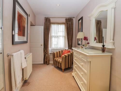 a bathroom with a dresser and a mirror at Old Book Shop in Grange Over Sands