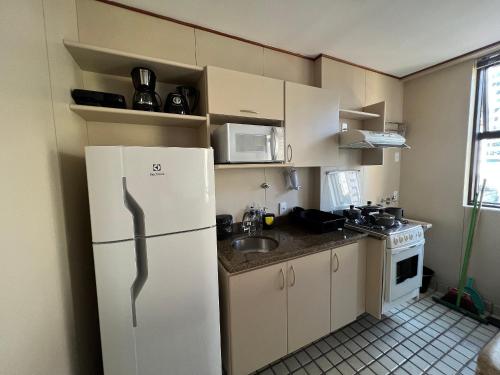 a small kitchen with a refrigerator and a sink at LK Funcionários 6 in Belo Horizonte