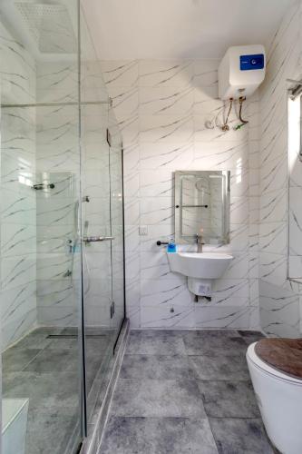 a white bathroom with a sink and a shower at Cecilia Homes in Lekki