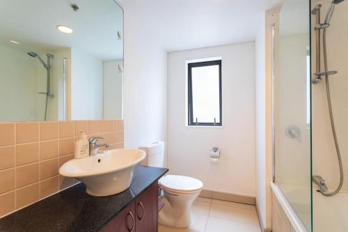 a bathroom with a sink and a toilet and a shower at Stunning Light-filled 2Bed w Car Park in Auckland