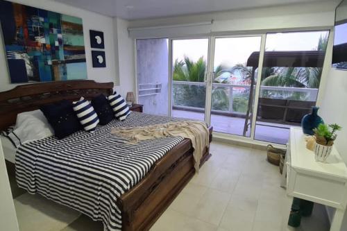圣安德烈斯Apartamento familiar en Sun Rise San Andrés的一间卧室，里面有一张床和一扇大窗户。