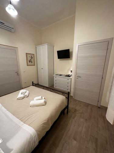 a bedroom with a bed with towels on it at Domo Achenza in Terralba
