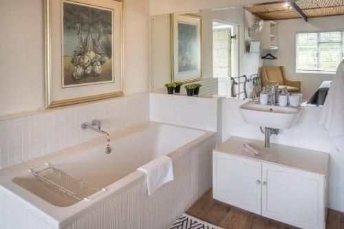 baño con bañera grande y lavamanos en The Vineyard Country House, en Montagu