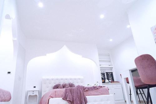 una camera da letto con un letto con una coperta rosa sopra di Casa il piccolo principe a Carovigno