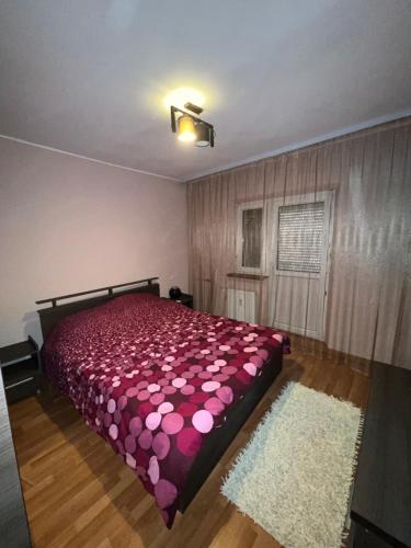 - une chambre avec un lit doté de draps roses et d'un tapis dans l'établissement LorIli’s Home, à Drobeta-Turnu Severin