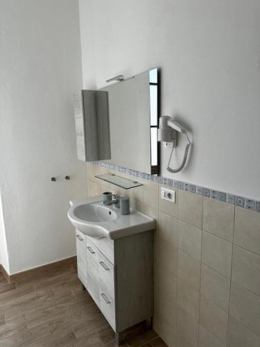 a bathroom with a sink and a mirror at Domo Achenza in Terralba