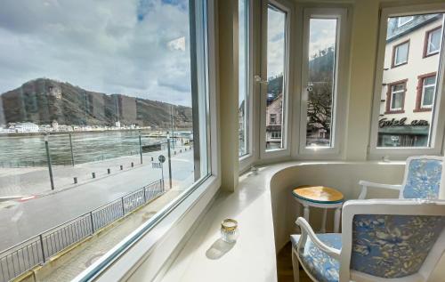 a room with windows and a view of the water at Hotel zum Goldenen Löwen in Sankt Goar