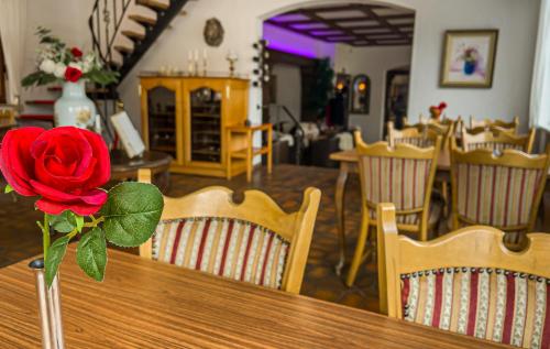 a rose in a vase on a wooden table at Hotel zum Goldenen Löwen in Sankt Goar