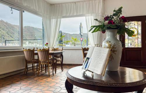 um quarto com uma mesa e um vaso com flores em Hotel zum Goldenen Löwen em Sankt Goar