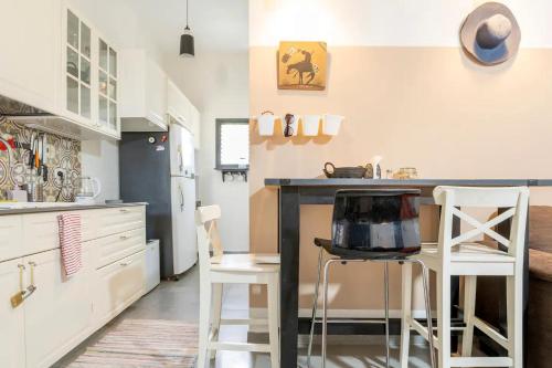 a kitchen with a counter and stools in a room at People LOVE this home! in Haifa