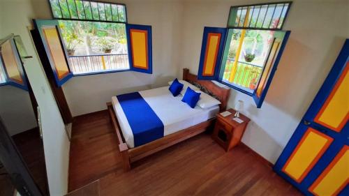 ein kleines Schlafzimmer mit einem Bett und einigen Fenstern in der Unterkunft Finca La Colmena De Don Juaco in Montenegro