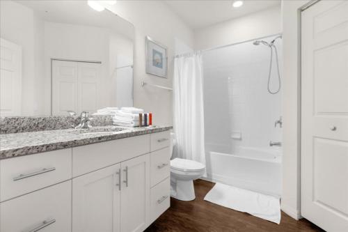 y baño blanco con aseo y ducha. en 4 Bedroom 3 Bathroom Lucaya Village 18-105 Lv, en Kissimmee