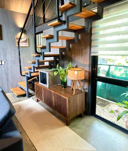 a living room with a staircase and a television at Studio Aloha - Malpais in Carmen
