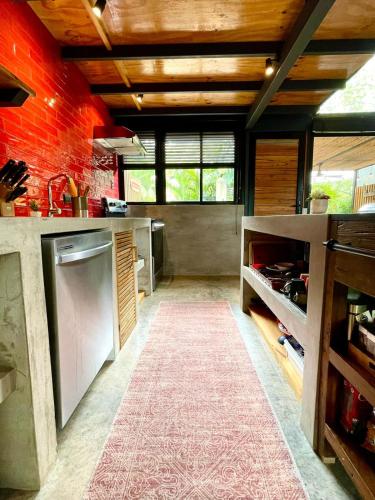 a large kitchen with a red brick wall at Studio Aloha - Malpais in Carmen
