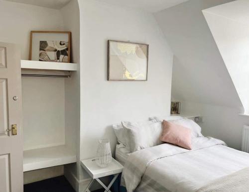 a white bedroom with a bed and a table at 4 bed loft apartment overlooking historic town in Trowbridge