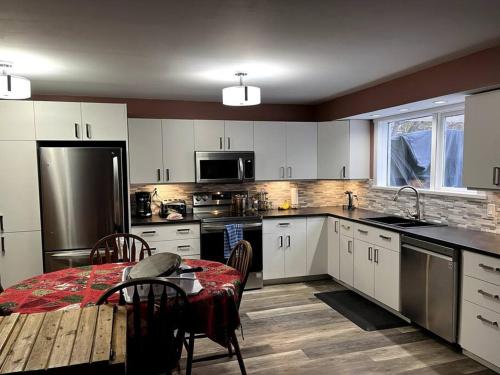 a kitchen with a table and a kitchen with white cabinets at Chez Michel and Marilyn in Vernon