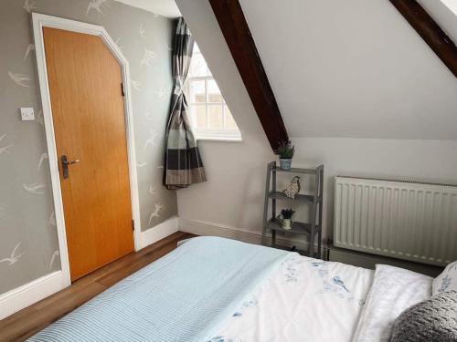 a bedroom with a bed and a wooden door at 4 bed loft apartment overlooking historic town in Trowbridge