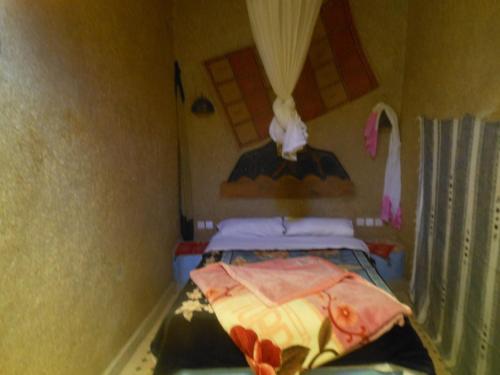 a small room with two beds and a window at Riad Aicha & Camel Trekking in Merzouga