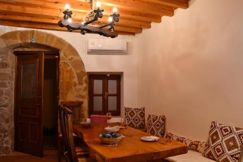 ein Esszimmer mit einem Holztisch und Stühlen in der Unterkunft The three story old town house in Rhodos (Stadt)