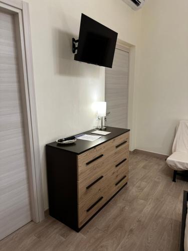 a room with a dresser with a television on top of it at Domo Achenza in Terralba