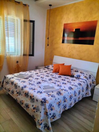 a bedroom with a bed with a blue and white comforter at R&B mediterraneo in Bosa