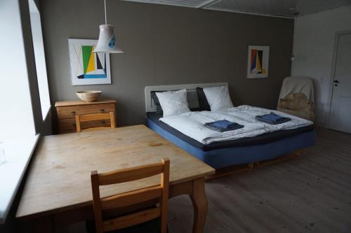 ノーポにあるMøllehusets Bed & Breakfastのベッドルーム1室(ベッド1台、木製テーブル付)