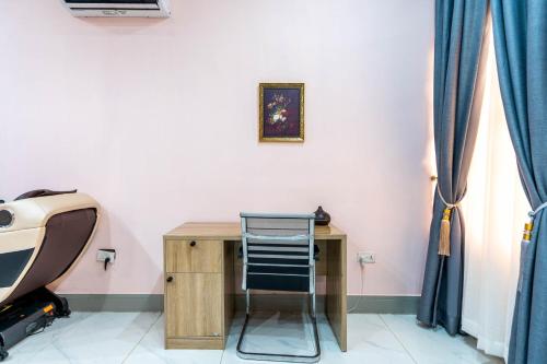 a wooden desk with a chair next to a wall at Cecilia Homes in Lekki