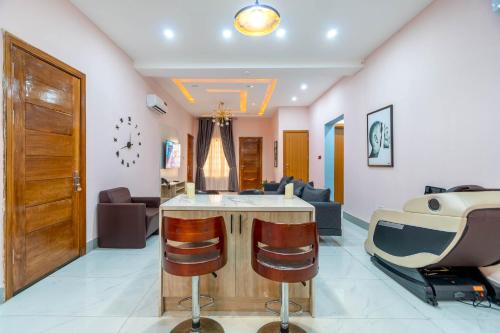 a salon with a bar with two bar stools at Cecilia Homes in Lekki