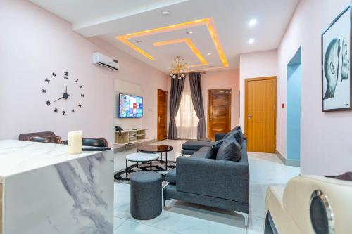 a living room with a couch and a clock on the wall at Cecilia Homes in Lekki