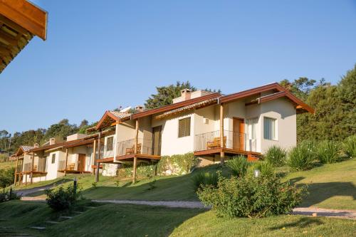 a row of houses with balconies on a lawn at Pousada Morro Verde in Águas de Lindóia