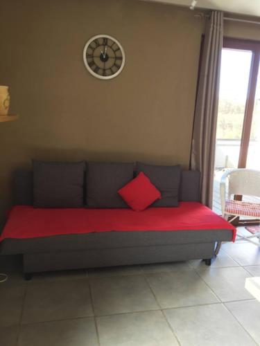 a couch in a room with a clock on the wall at Relax Semois in Vresse-sur-Semois