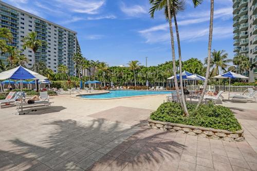 a pool at a resort with palm trees and umbrellas at Ocean Reserve Condominium in Miami Beach