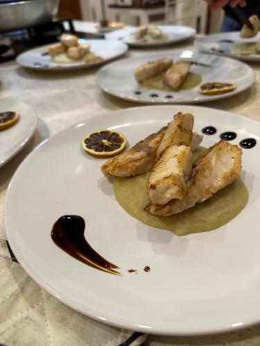 a white plate with food on a table at Domo Achenza in Terralba
