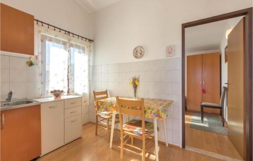 kuchnia ze stołem, krzesłami i zlewem w obiekcie One-Bedroom Apartment In Medulin w Medulinie