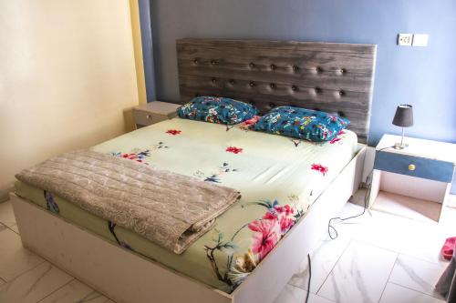 Un dormitorio con una cama con flores. en DALOU Chambre hôte, Cité mixta en Dakar