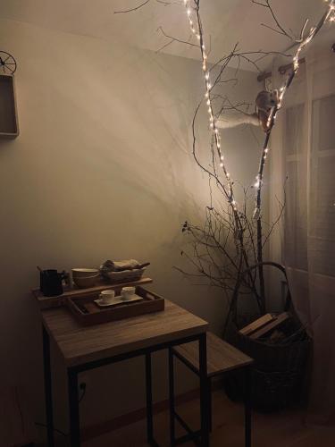 a table with a tree with lights on it at Le Nid Douillet in Plancher-Bas