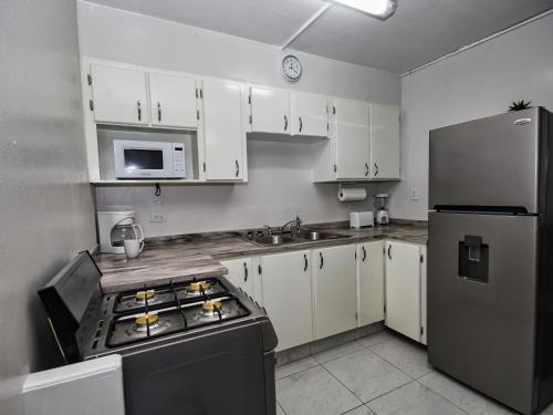 a kitchen with white cabinets and a stainless steel refrigerator at The Castle in Philipsburg
